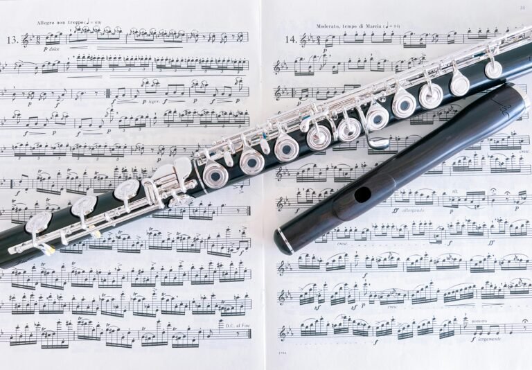 Close-up of a flute resting on sheet music pages, emphasizing musical composition.