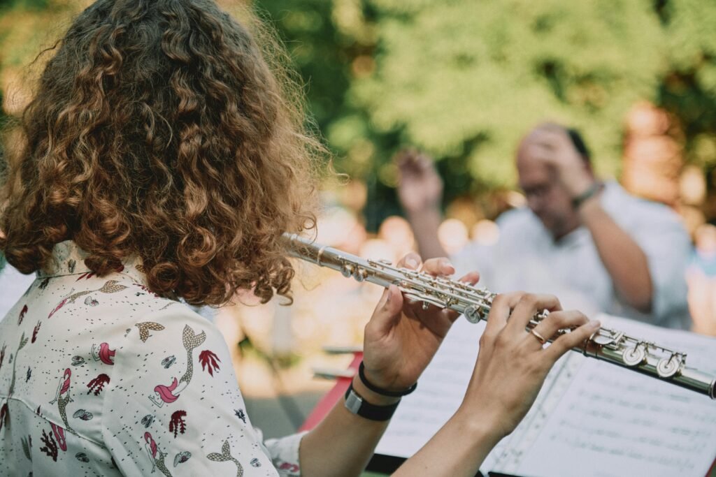 woman in white red and green floral shirt playing trumpet woman in white red and green floral shirt playing trumpet